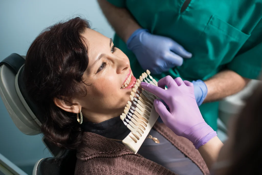 Dentista evaluando el color ideal de los dientes para un implante dental, asegurando un resultado natural y estético.