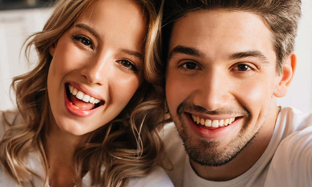 Pareja joven enseñando su diseño de sonrisa